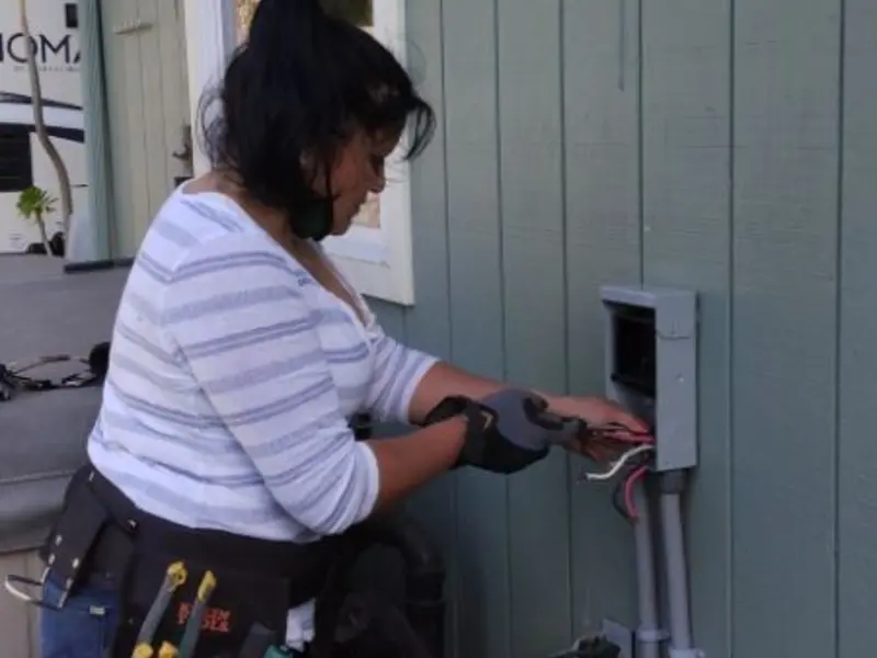 Licensed electrician wiring an exterior subpanel in Alden